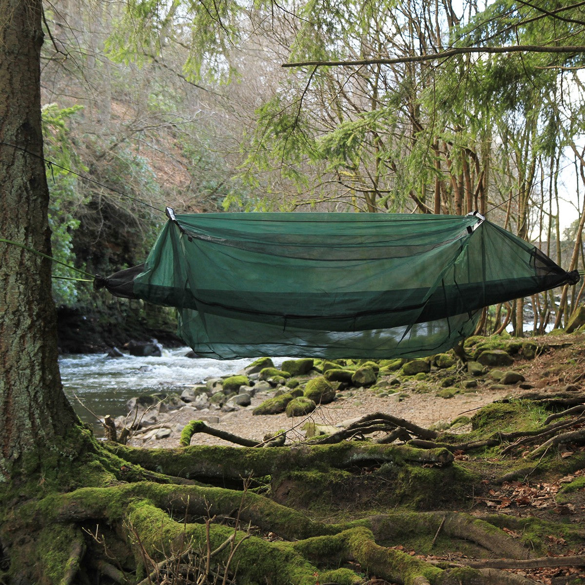 Hengekøye med DD Hammock Mosquito Net over, hengt mellom trær ved en elv
