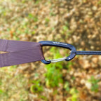 Nærbilde av en DD-karabiner som kobler en brun trestropp til en tynn slynge
