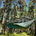DD SuperLight Frontline Hammock med myggnett hengt mellom furutrær i sol