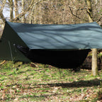 DD SuperLight Tarp i Olivengrønn spent over en hengekøye med myggnett i skogen