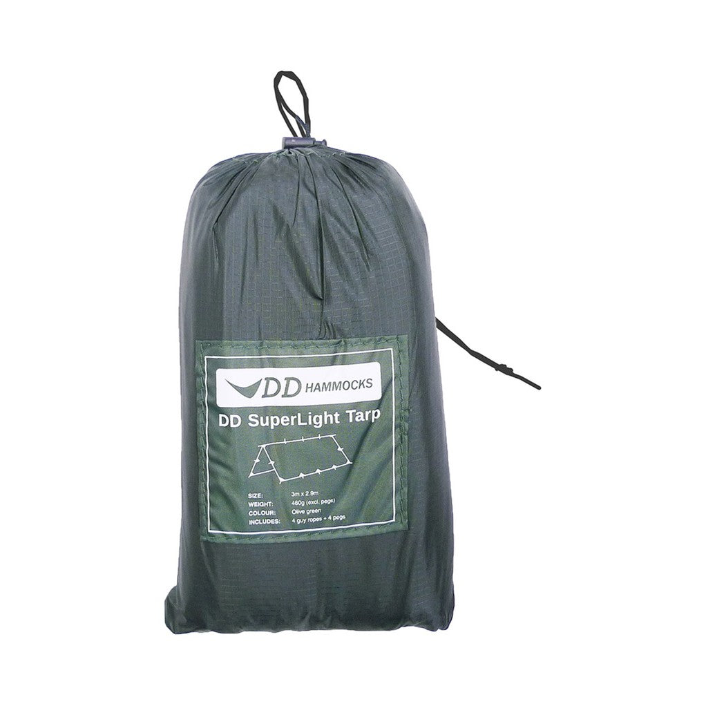 DD SuperLight Tarp i Olivengrønn pakket i posen. Etiketten viser 3 m × 2,9 m og 460 g uten plugger
