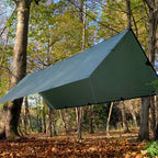 DD Tarp XL i Olivengrønn spent opp som tak høyt mellom trærne i en høstskog